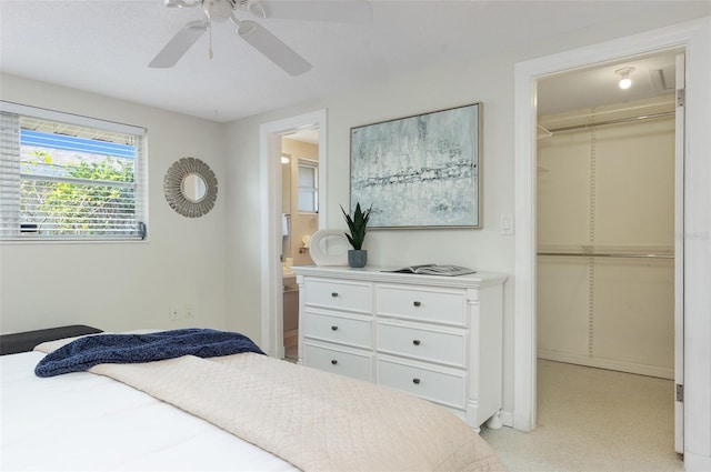 bedroom with ceiling fan, a walk in closet, ensuite bathroom, and a closet