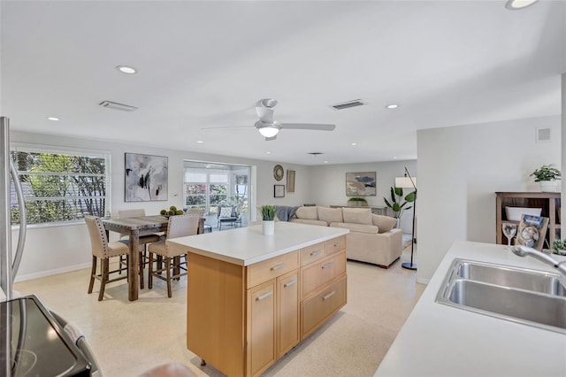 2321 Terry Ln, Sarasota, FL 34231 - kitchen featuring a sink, baseboards, recessed lighting, light countertops, and a kitchen island