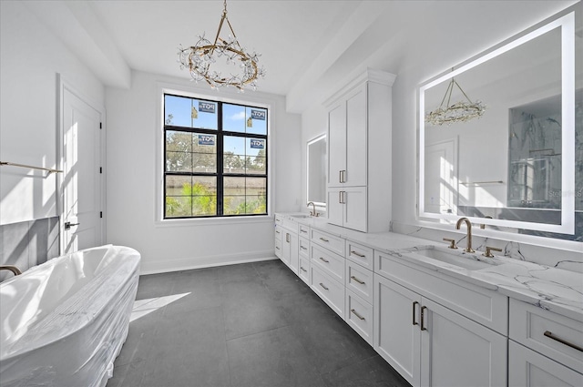 bathroom featuring an inviting chandelier, vanity, and a tub