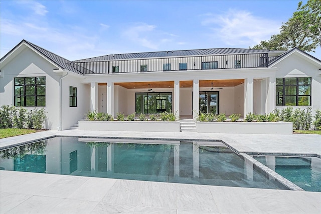 656 Tropical Cir, Sarasota, FL 34242 - back of property featuring a standing seam roof, a ceiling fan, a patio area, and stucco siding