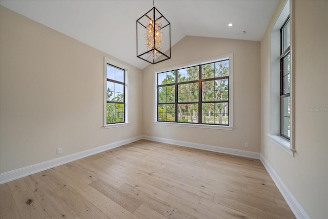 656 Tropical Cir, Sarasota, FL 34242 - spare room featuring baseboards, an inviting chandelier, light wood-style flooring, and vaulted ceiling