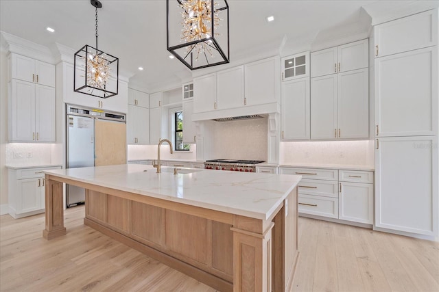656 Tropical Cir, Sarasota, FL 34242 - kitchen with a notable chandelier, decorative backsplash, a sink, and light wood finished floors