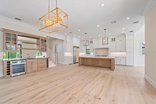 656 Tropical Cir, Sarasota, FL 34242 - kitchen with a sink, light wood finished floors, beverage cooler, refrigerator, and visible vents