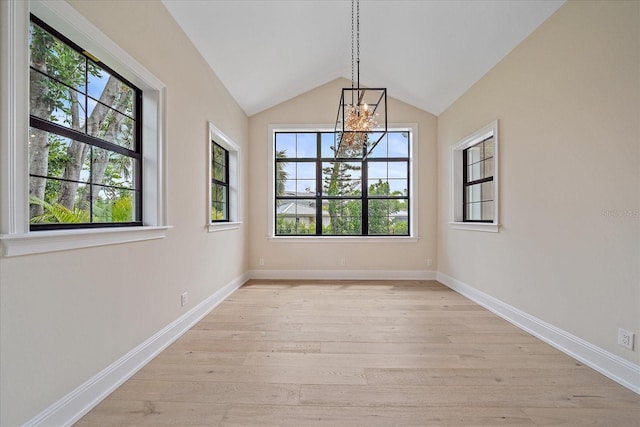 656 Tropical Cir, Sarasota, FL 34242 - unfurnished dining area with light wood-style floors, baseboards, a notable chandelier, and lofted ceiling