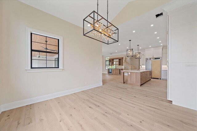 656 Tropical Cir, Sarasota, FL 34242 - interior space with baseboards, an inviting chandelier, a sink, and light wood finished floors