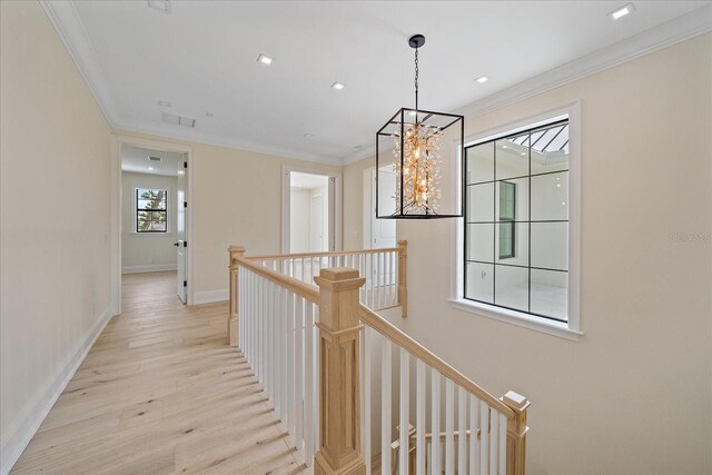 656 Tropical Cir, Sarasota, FL 34242 - hall featuring visible vents, ornamental molding, a chandelier, light wood finished floors, and an upstairs landing