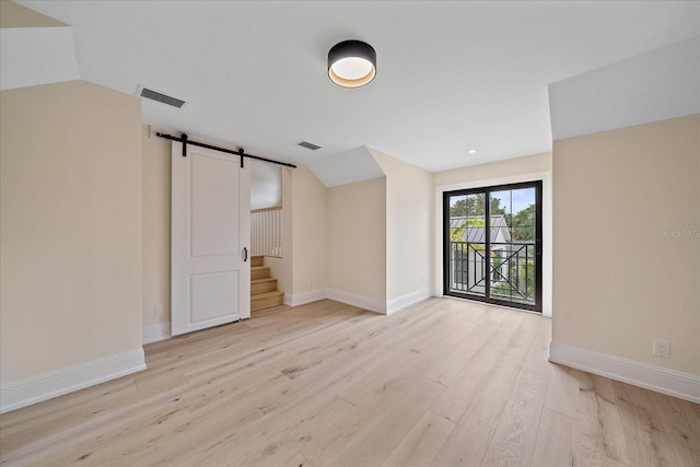656 Tropical Cir, Sarasota, FL 34242 - interior space with baseboards, visible vents, a barn door, and light wood-style floors