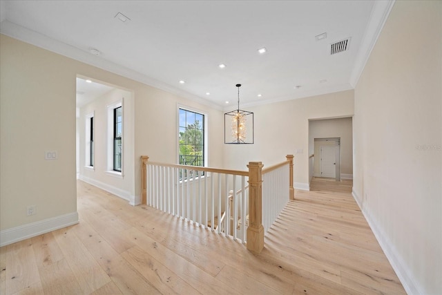656 Tropical Cir, Sarasota, FL 34242 - hall with an inviting chandelier, an upstairs landing, light wood-type flooring, visible vents, and ornamental molding