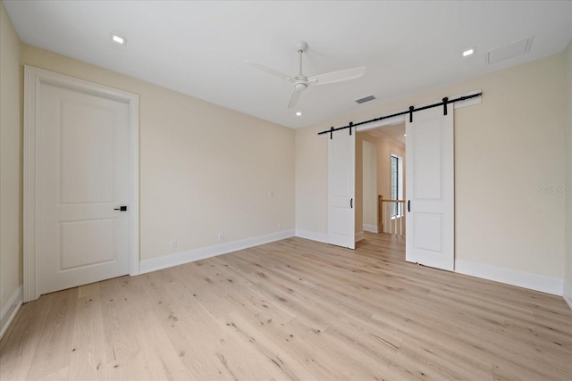 656 Tropical Cir, Sarasota, FL 34242 - spare room featuring a barn door, a ceiling fan, light wood-style flooring, and visible vents