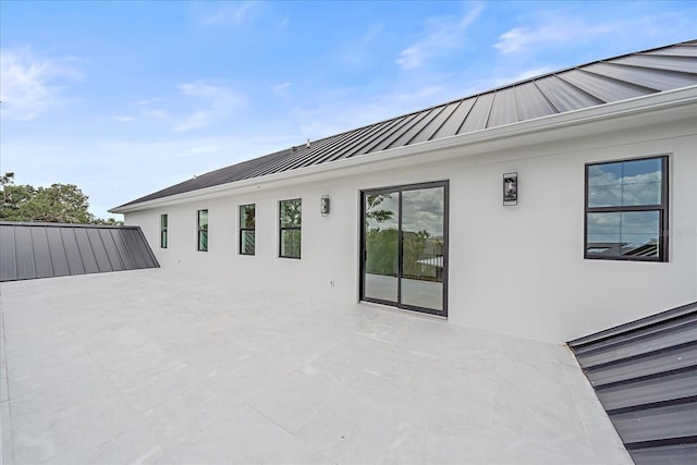 656 Tropical Cir, Sarasota, FL 34242 - rear view of property featuring a standing seam roof, a patio, stucco siding, and metal roof