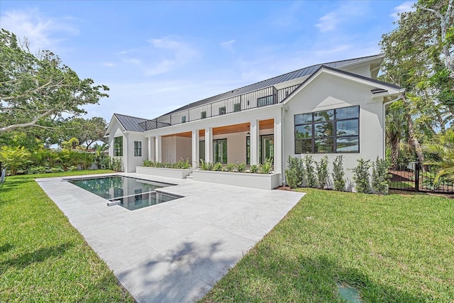 656 Tropical Cir, Sarasota, FL 34242 - back of property featuring a yard, a patio, a standing seam roof, and stucco siding