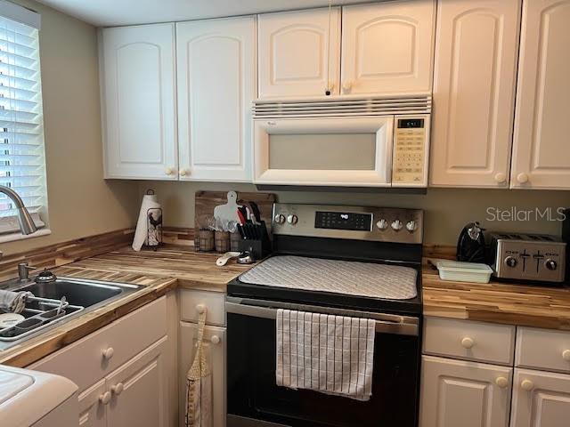 kitchen featuring sink, white cabinets, and stainless steel electric range oven