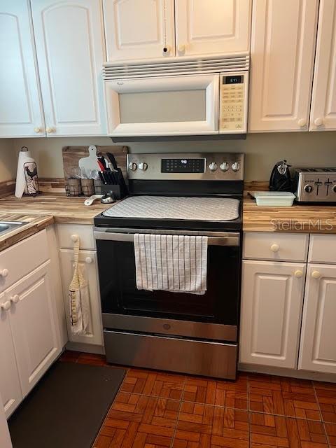 kitchen featuring white cabinetry and stainless steel electric stove