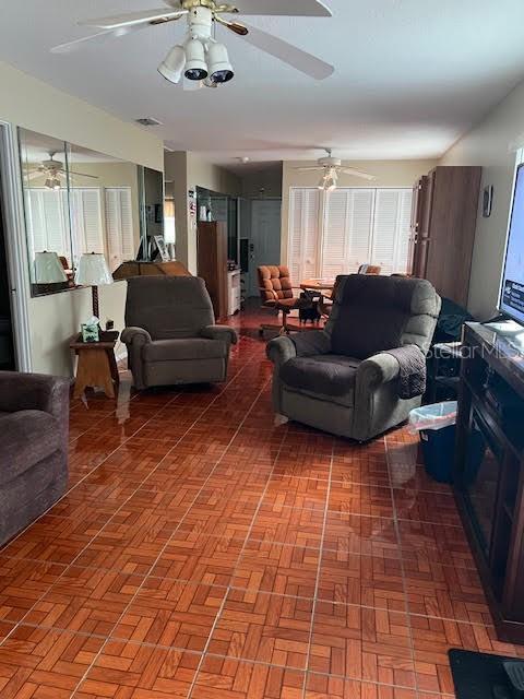 living room with parquet flooring and ceiling fan