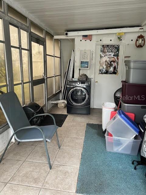 clothes washing area featuring washer / clothes dryer and light tile patterned floors