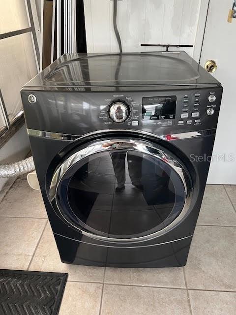 laundry area with tile patterned floors and washer / dryer