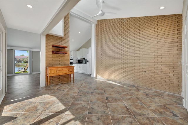 interior space featuring ceiling fan, high vaulted ceiling, beamed ceiling, and brick wall