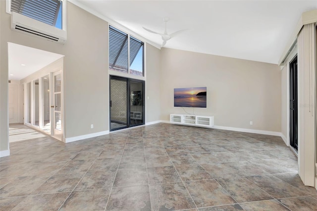 unfurnished living room with a towering ceiling and a wall mounted AC