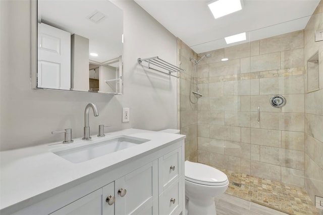 bathroom featuring vanity, toilet, and a shower with door