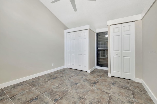 unfurnished bedroom featuring ceiling fan, vaulted ceiling, tile patterned floors, and multiple closets