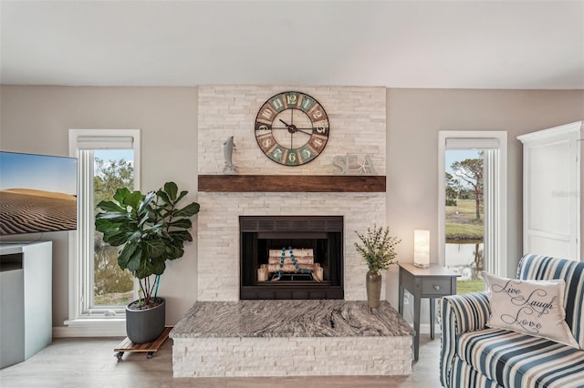 living room featuring light hardwood / wood-style flooring, a wealth of natural light, and a fireplace