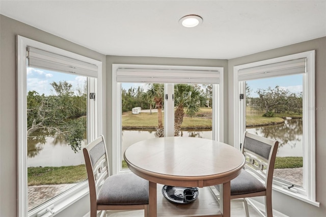 sunroom featuring a wealth of natural light and a water view