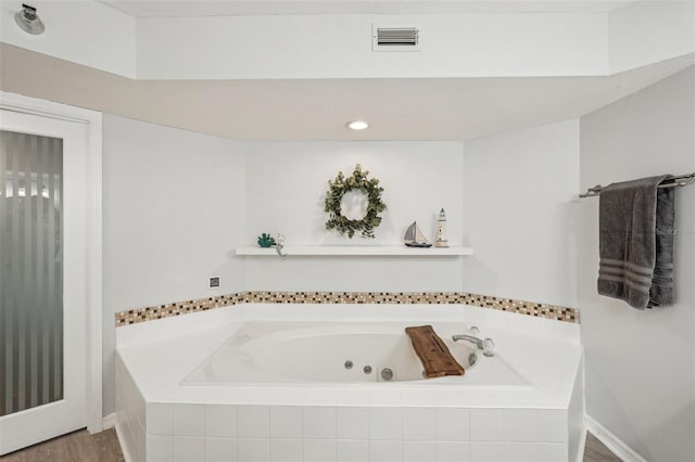 bathroom featuring tiled tub