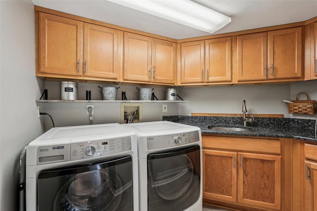 clothes washing area featuring cabinets, sink, and independent washer and dryer