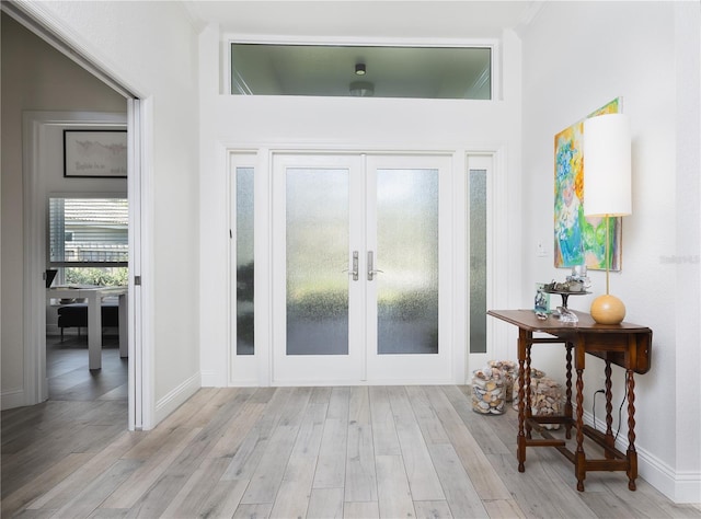 foyer entrance with french doors and light hardwood / wood-style flooring