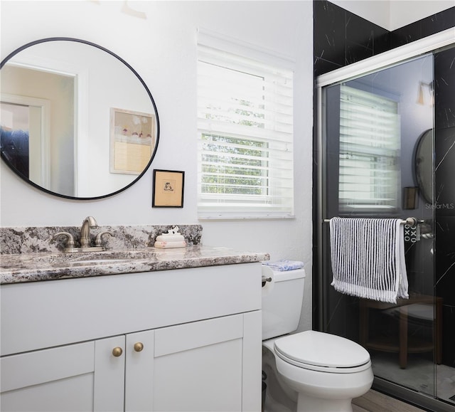 bathroom with vanity, an enclosed shower, and toilet