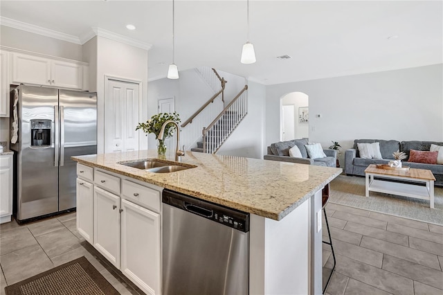 kitchen featuring sink, white cabinetry, a center island with sink, appliances with stainless steel finishes, and pendant lighting