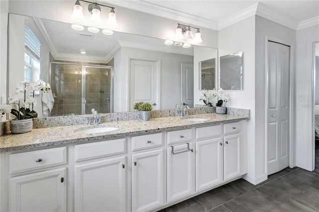 bathroom featuring a shower with door, crown molding, vanity, and tile patterned floors