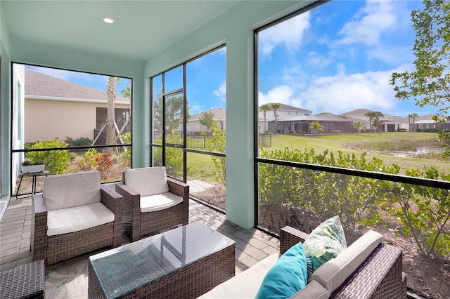 sunroom / solarium featuring a water view