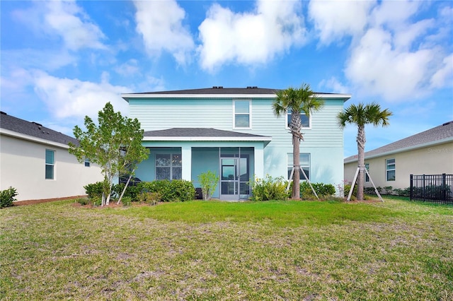 back of property with a lawn and a sunroom