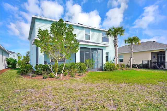 back of property with a yard and a sunroom