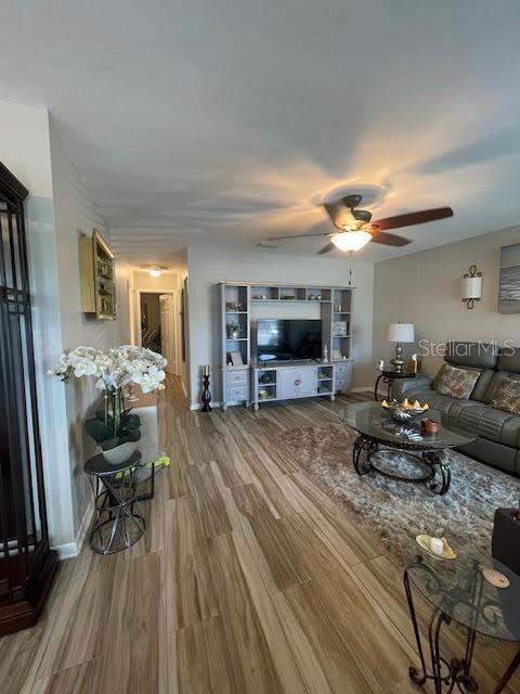 living room with wood-type flooring and ceiling fan