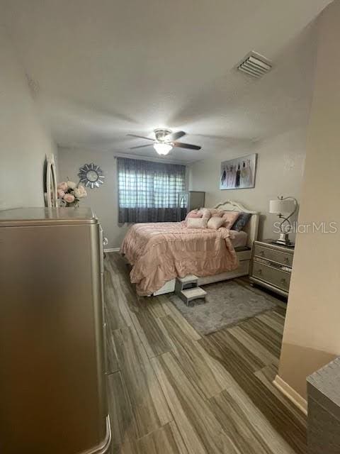 bedroom with ceiling fan and dark hardwood / wood-style flooring