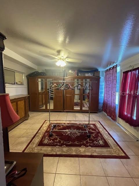 living room featuring light tile patterned floors and ceiling fan