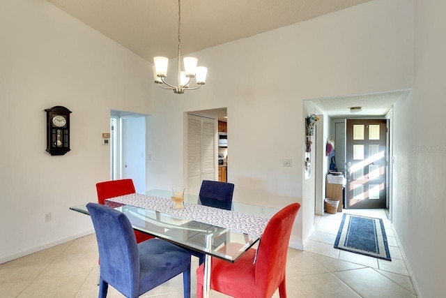 tiled dining space featuring a high ceiling and a chandelier