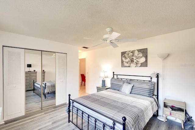 bedroom featuring hardwood / wood-style floors, a textured ceiling, and a closet