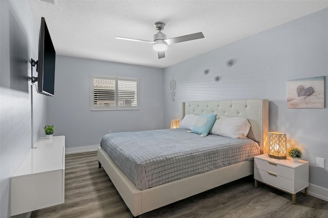 bedroom with ceiling fan, dark hardwood / wood-style floors, and a textured ceiling