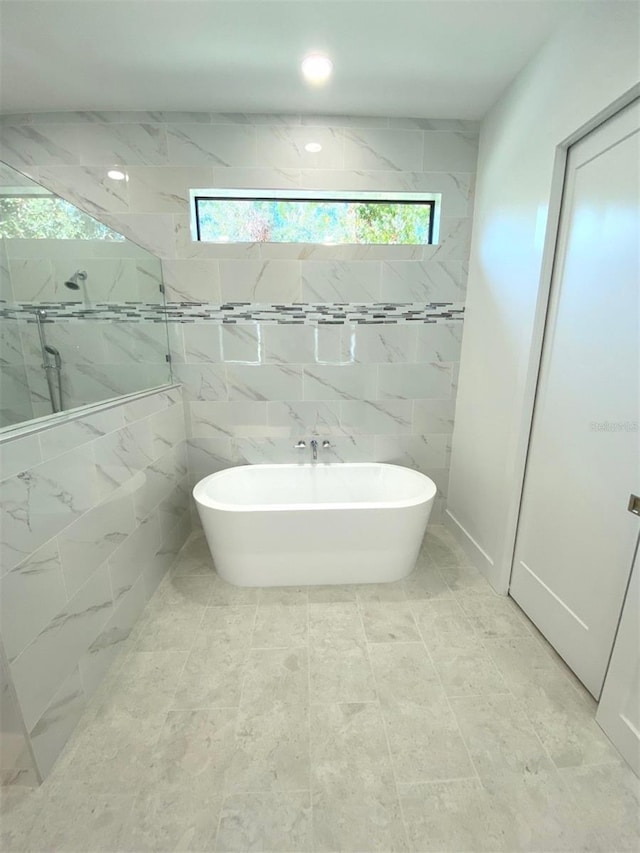 bathroom featuring a freestanding tub and tiled shower