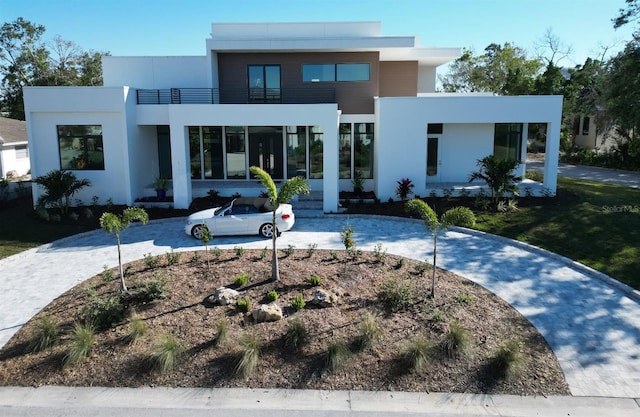 view of front facade with a balcony and stucco siding