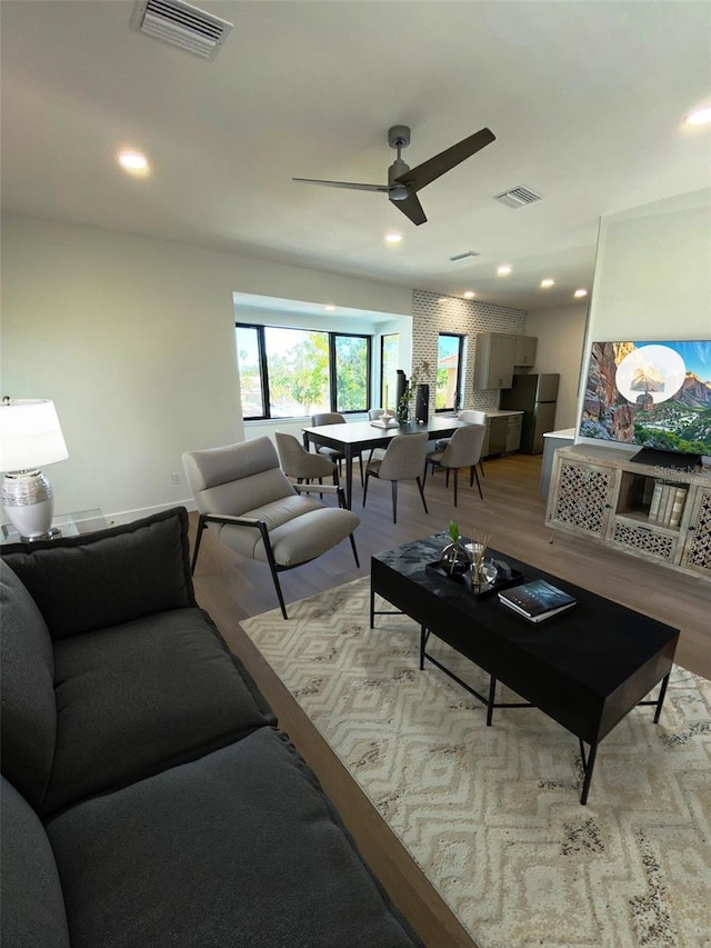 living area featuring light wood-type flooring, visible vents, and recessed lighting