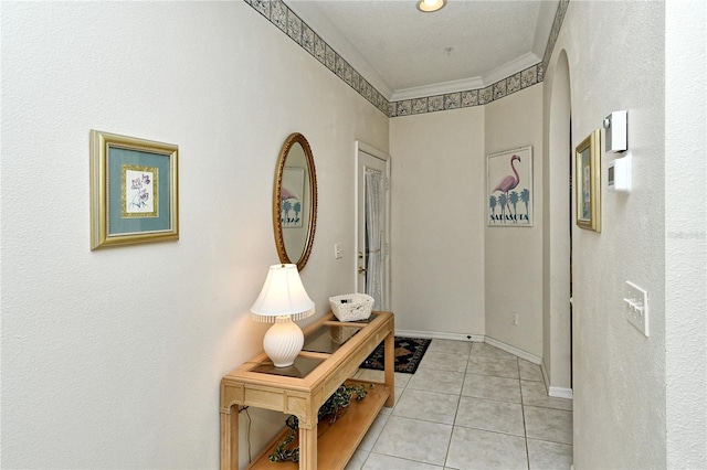 hallway featuring ornamental molding and light tile patterned flooring