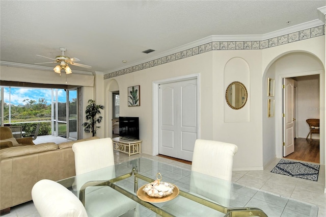 dining room with ornamental molding, a textured ceiling, and light tile patterned floors