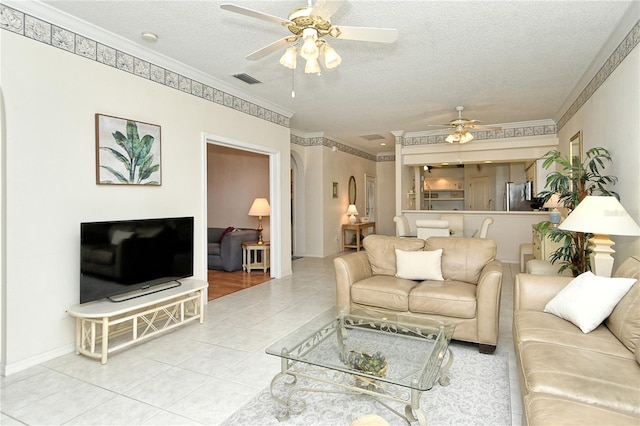 tiled living room with ceiling fan, crown molding, and a textured ceiling