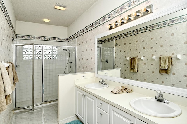 bathroom featuring an enclosed shower, vanity, tile patterned flooring, and a textured ceiling