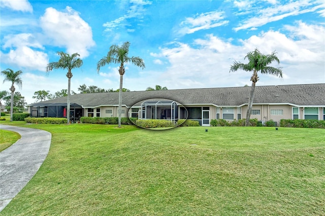 ranch-style home featuring a front lawn and glass enclosure