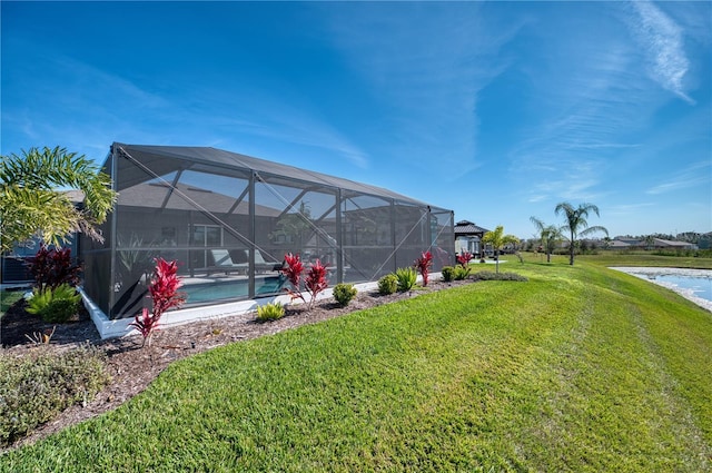 view of yard with a water view and glass enclosure